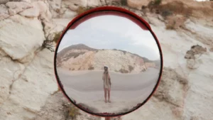 Small figure reflected in a round outdoor mirror