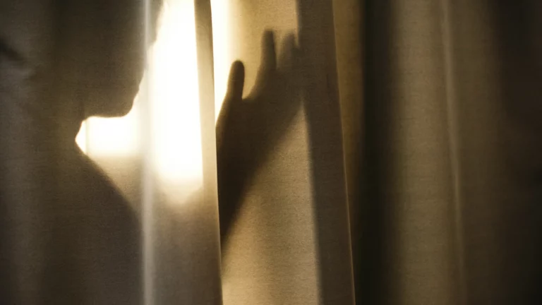 Human silhouette behind a translucent curtain