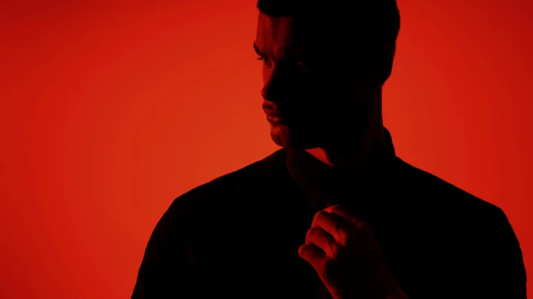 Young man in silhouette against a red background